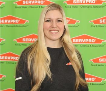 female SERVPRO employee in front of green backdrop