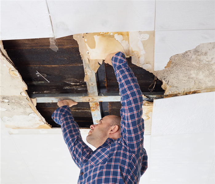 man touching collapsed ceiling